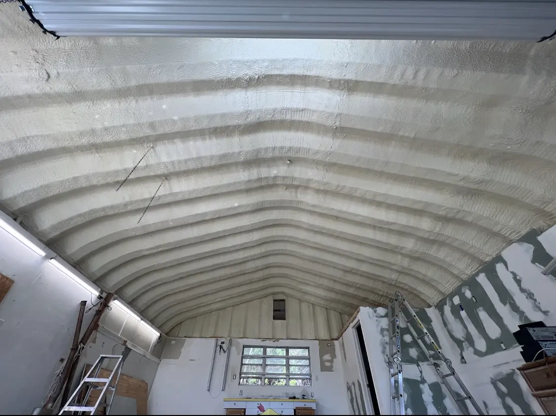 Spray polyurethane foam applied to the underside of a metal roof deck in East Aurora
